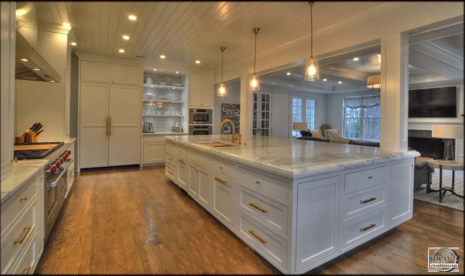 A large kitchen with white cabinets and marble counter tops