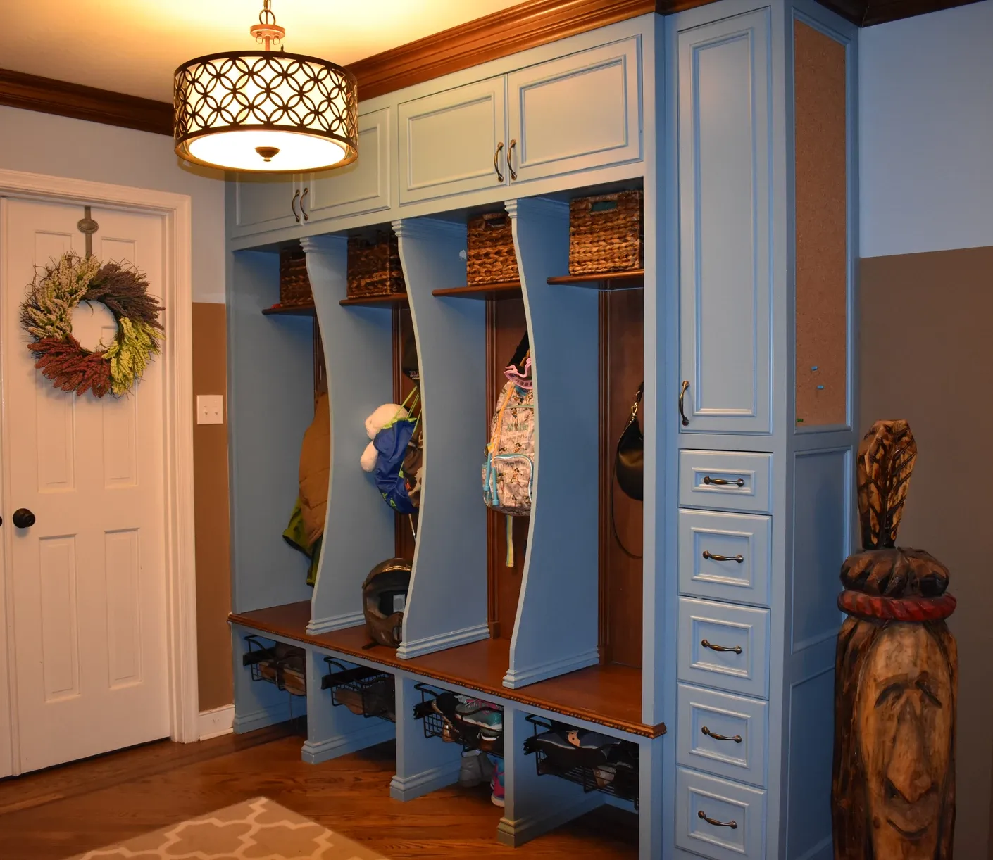 A hallway with blue cabinets and a wreath on the door