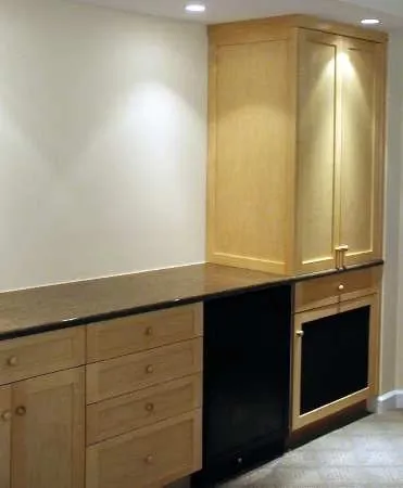 A kitchen with wooden cabinets and a black refrigerator