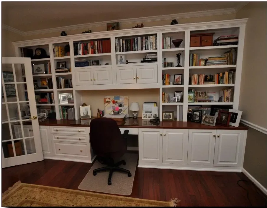 A desk with a chair in front of a wall of bookshelves