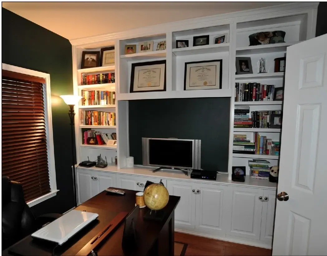 A room with lots of shelves and a flat screen tv