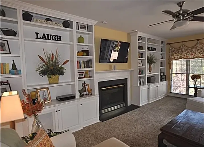 A living room with a fireplace and a sign that says laugh