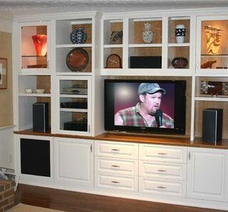 A man in a plaid shirt is speaking into a microphone on a flat screen tv