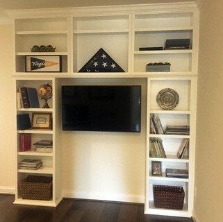 A living room with shelves and a flat screen tv