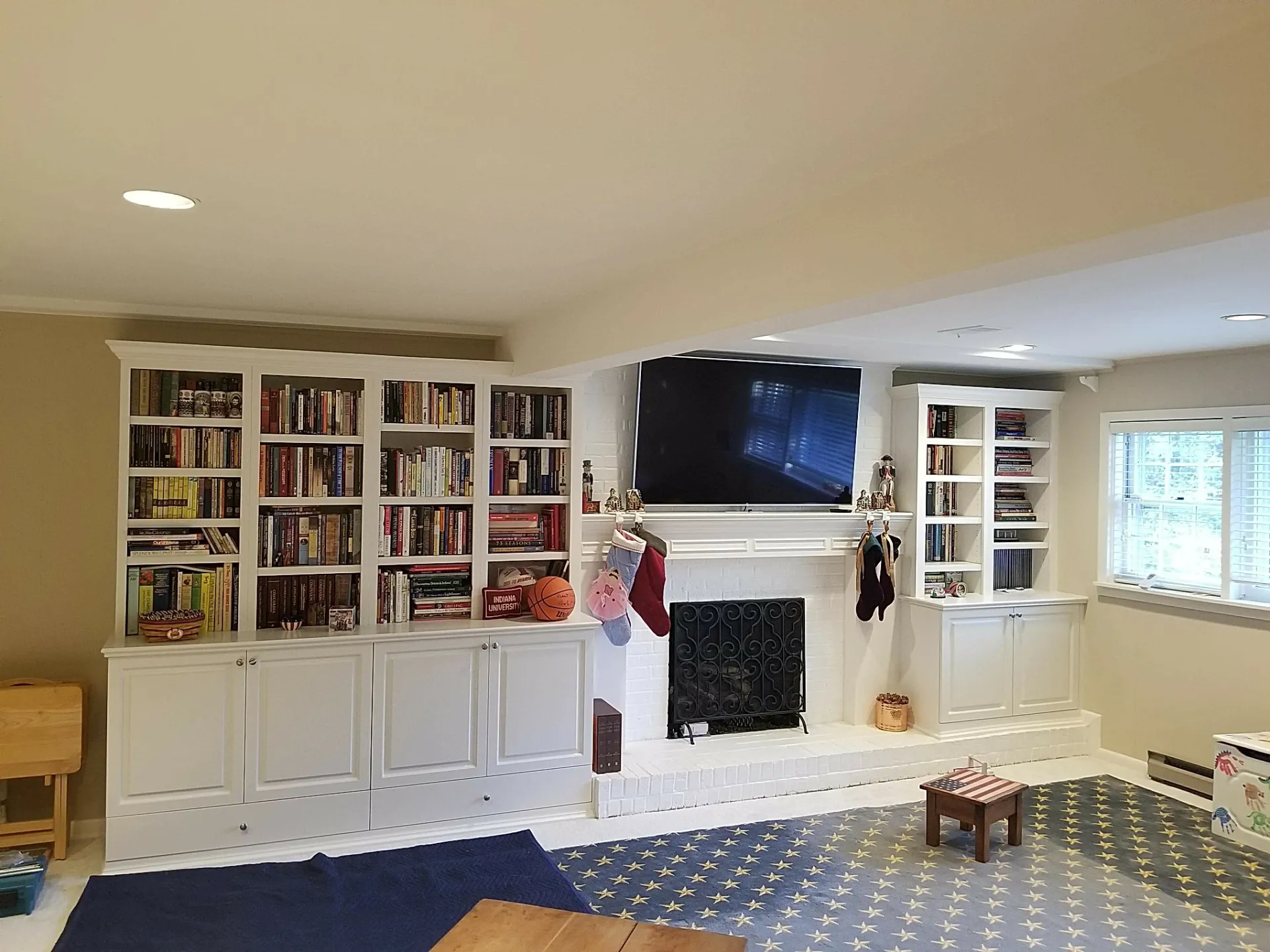 A living room with lots of bookshelves and a fireplace