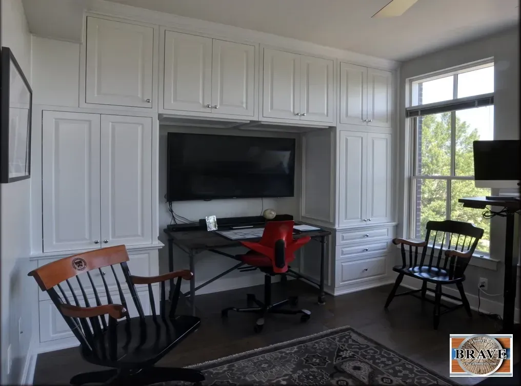 A room with two chairs a desk and a flat screen tv