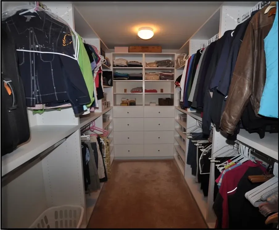A walk in closet filled with clothes and a basket
