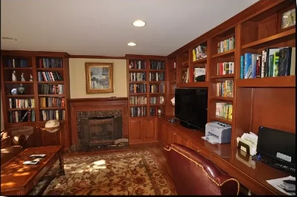 A living room with lots of bookshelves and a fireplace