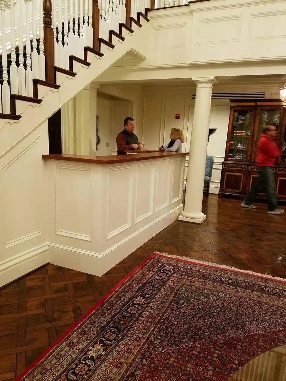 A man stands at a counter in front of a staircase