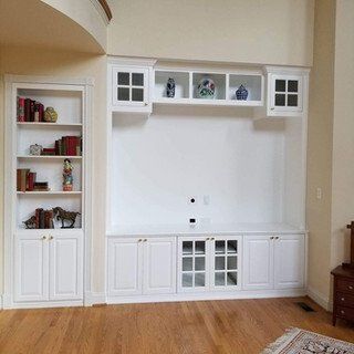 A living room with hardwood floors and white cabinets
