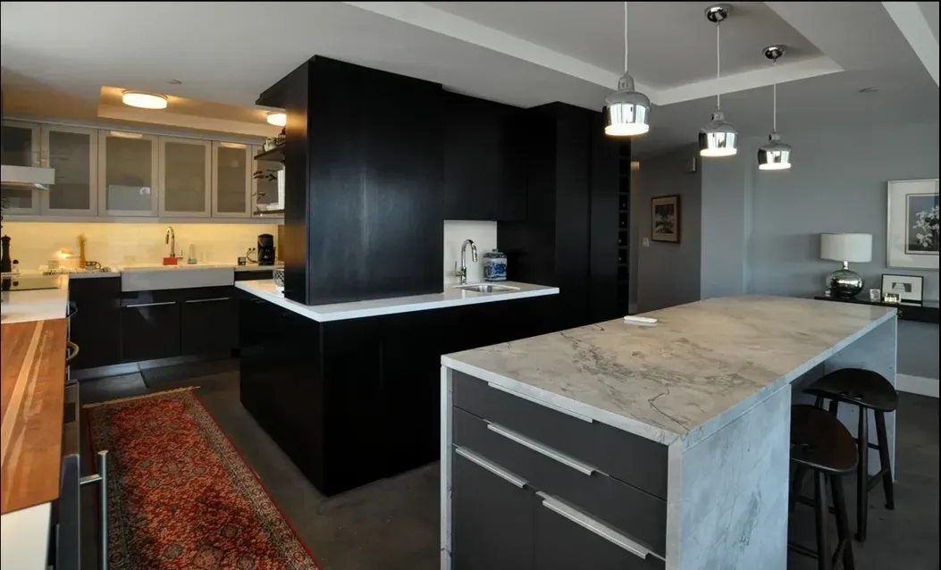 A kitchen with black cabinets and white counter tops