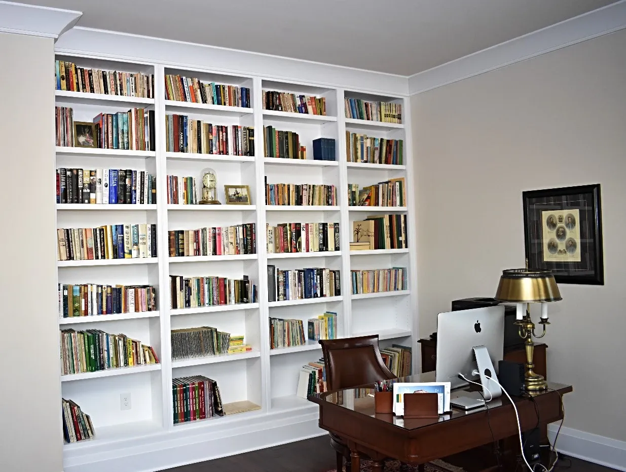 A library with lots of books on shelves and a desk