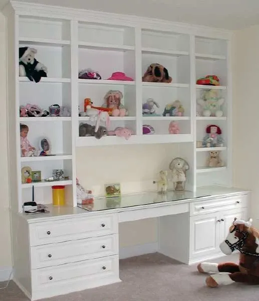 A room with a desk and shelves filled with stuffed animals