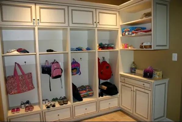 A room with a lot of shelves and drawers and backpacks