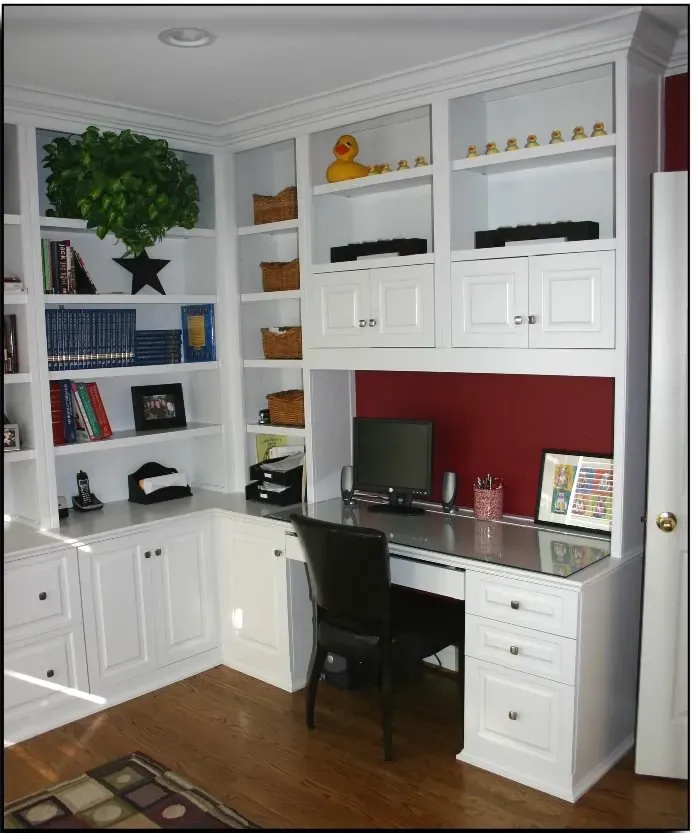 A home office with white cabinets and a desk