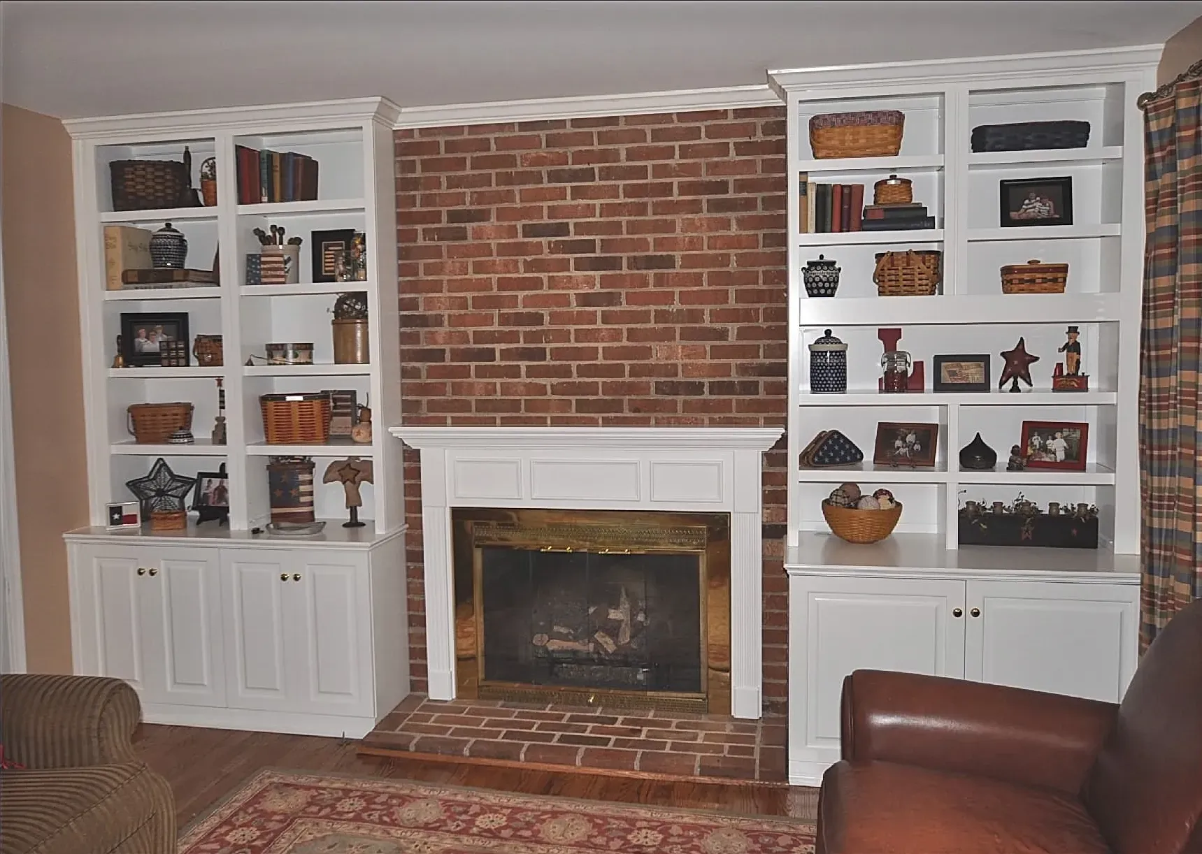 A living room with a fireplace and built in shelves