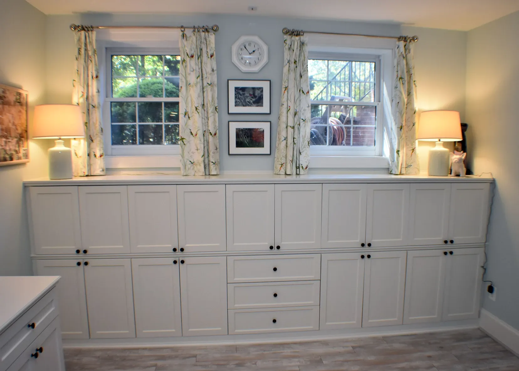 A room with white cabinets and a clock on the wall