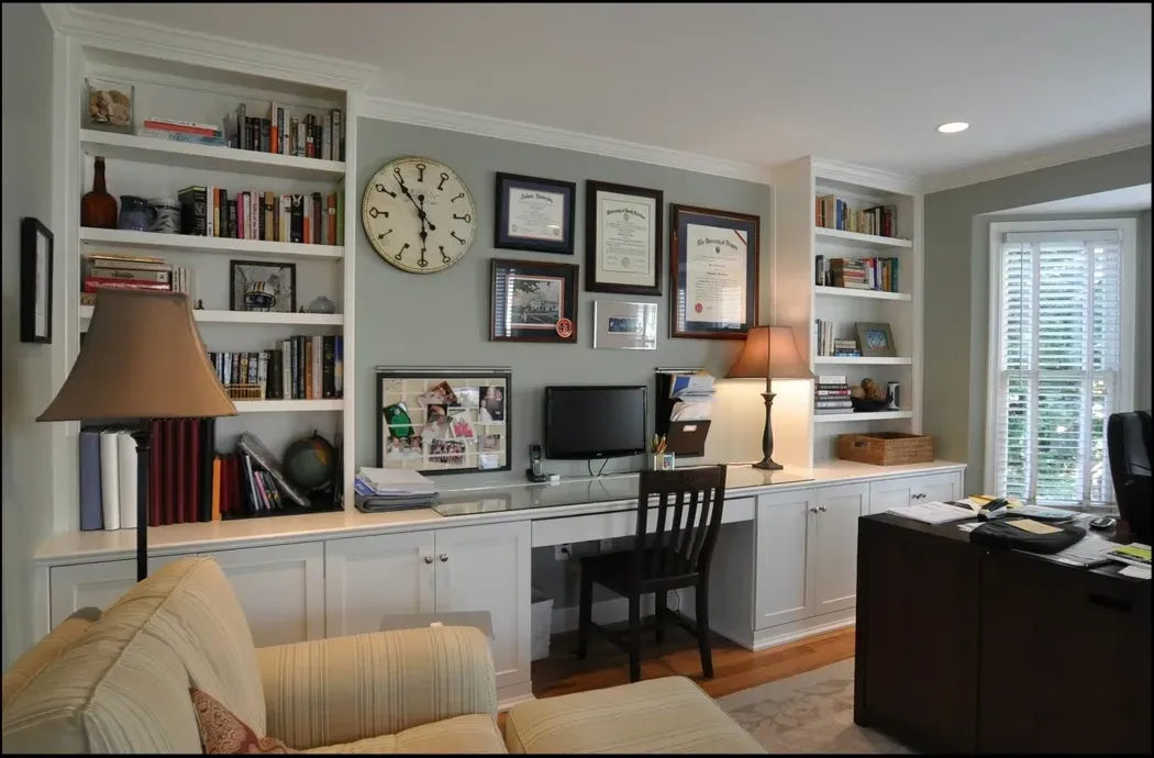 A living room with a desk and a clock on the wall