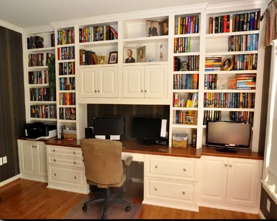 A home office with lots of books on the shelves