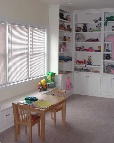 A room with a table and chairs in front of a window