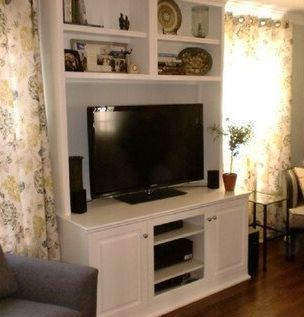 A living room with a flat screen tv on a white entertainment center