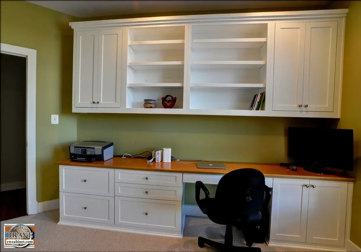 A home office with white cabinets and a black chair