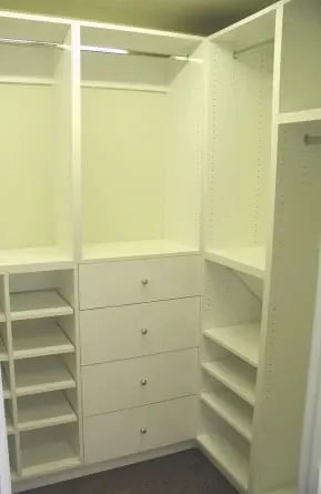 A walk in closet with lots of shelves and drawers.
