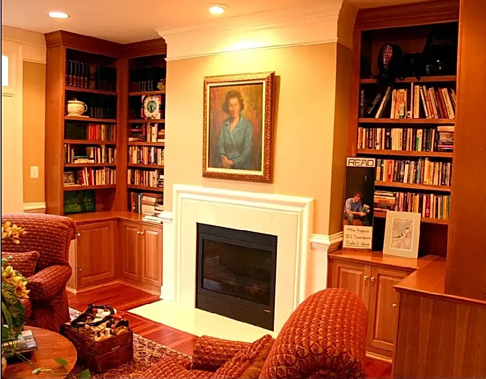 A living room with a fireplace and a painting on the wall