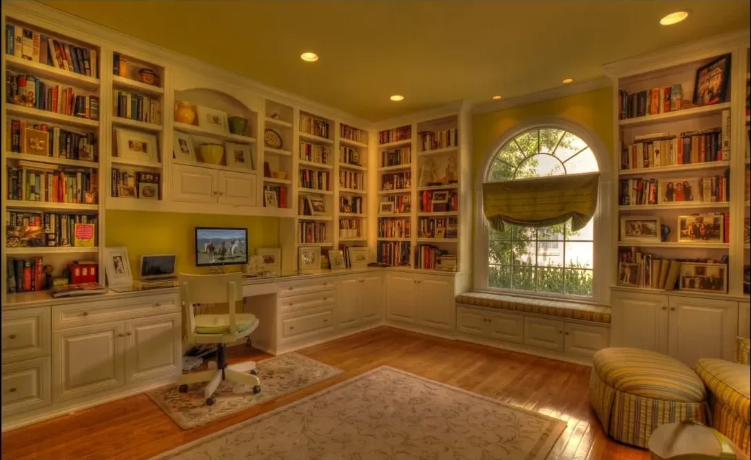 A room with lots of bookshelves and a window