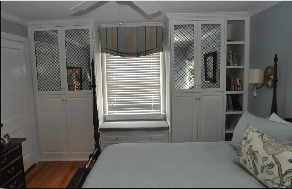 A bedroom with a bed and a window with blinds