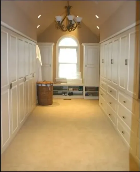 A walk in closet with lots of cabinets and drawers