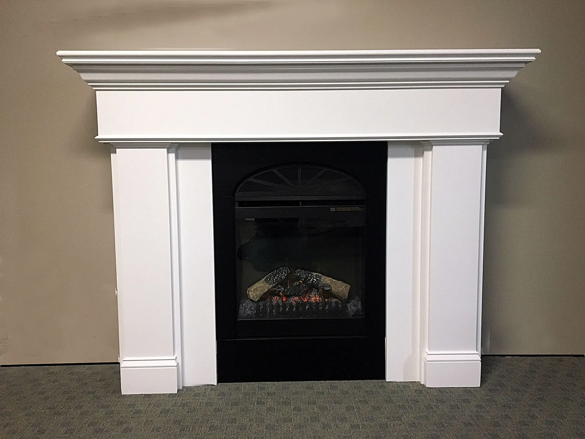 A fireplace with a white mantle and a black door
