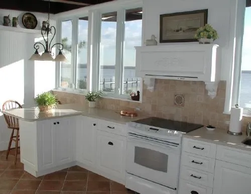 A kitchen with white cabinets and a stove top oven