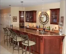 A picture of a kitchen with a bar and stools