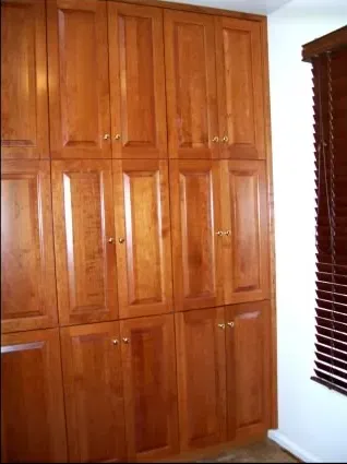 A room with lots of wooden cabinets and a window