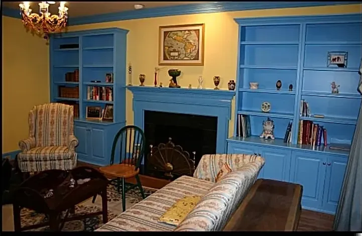 A living room with blue furniture and a fireplace