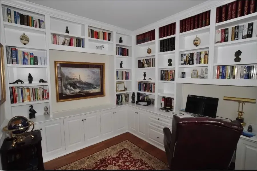 A library with lots of books and a picture on the wall