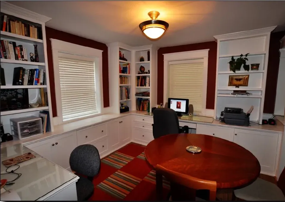 A home office with a round table and a computer