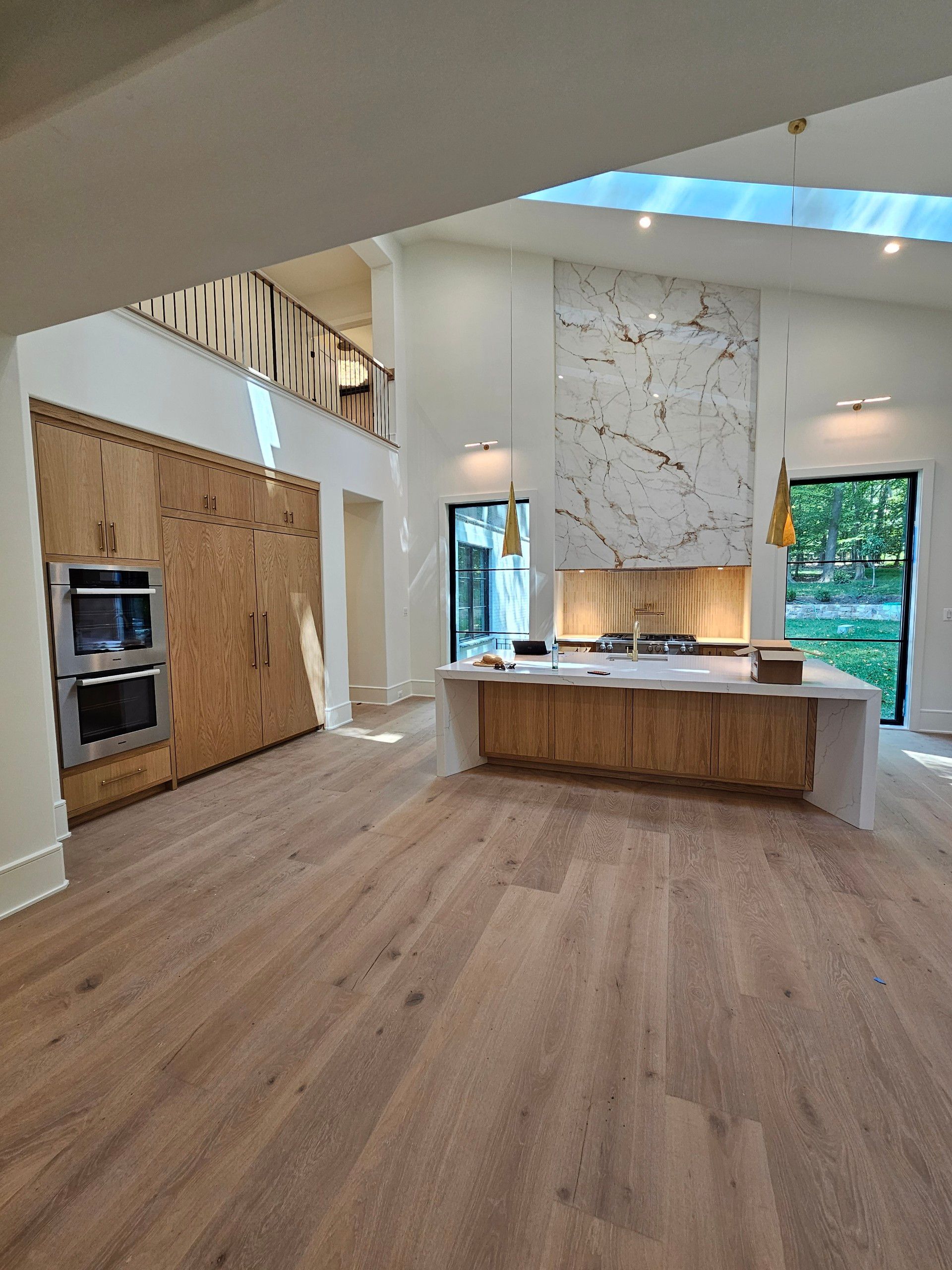 An empty kitchen with wooden floors and a large island