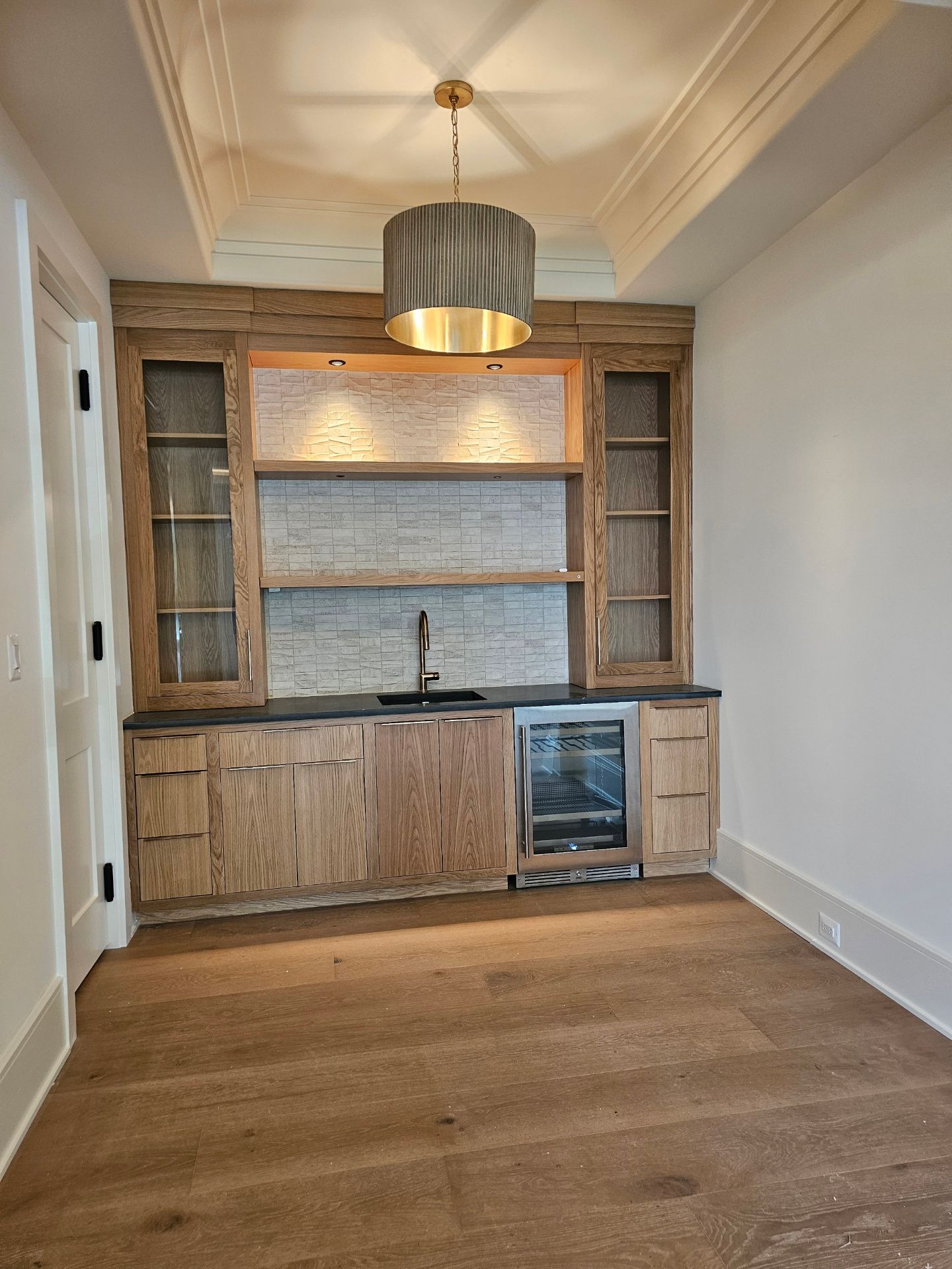 A kitchen with wooden cabinets and a wine cooler