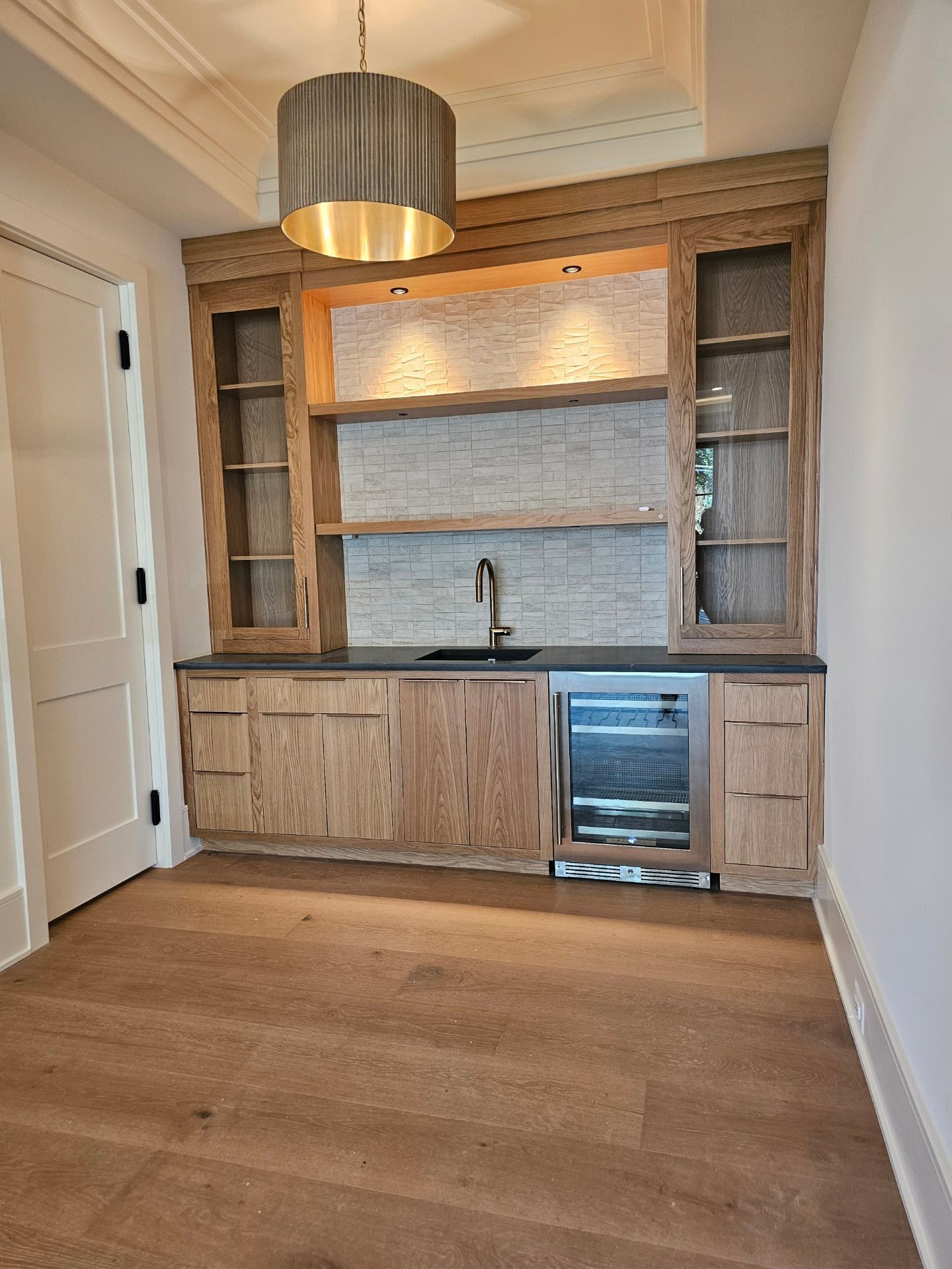 A kitchen with wooden cabinets and a stainless steel refrigerator