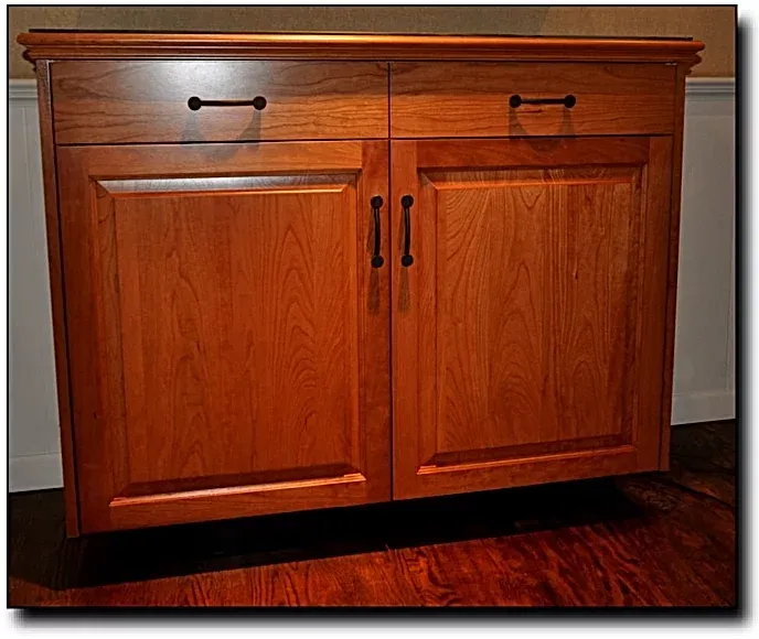 A wooden cabinet with two doors and a drawer