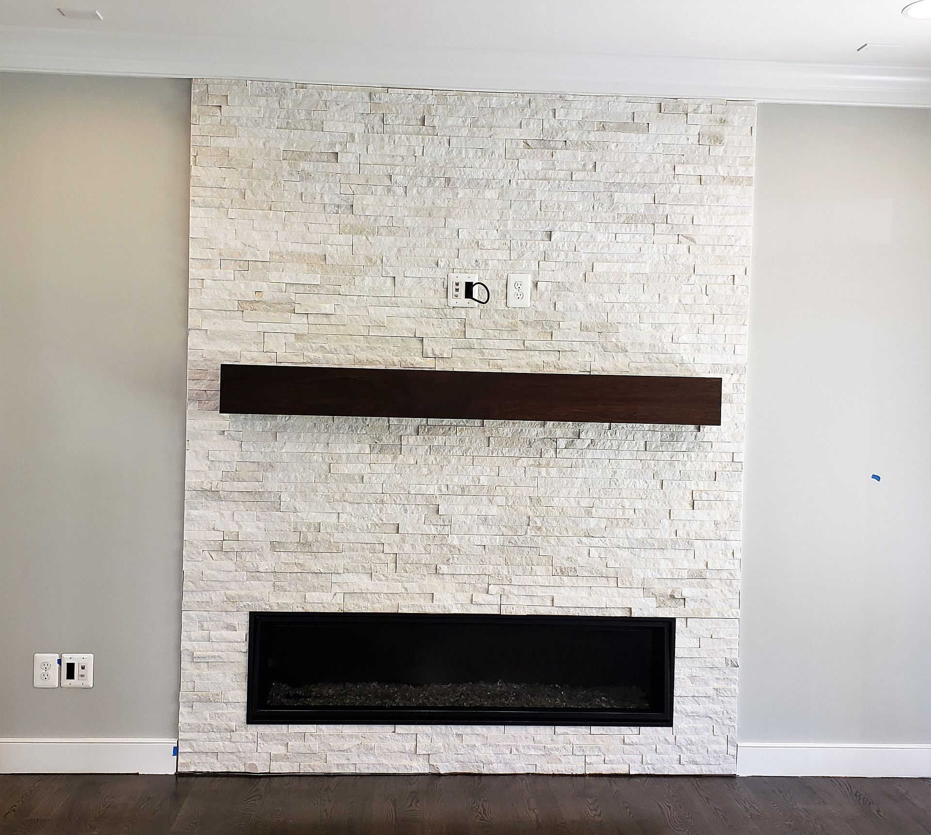 A fireplace with a brick wall and a wooden mantle