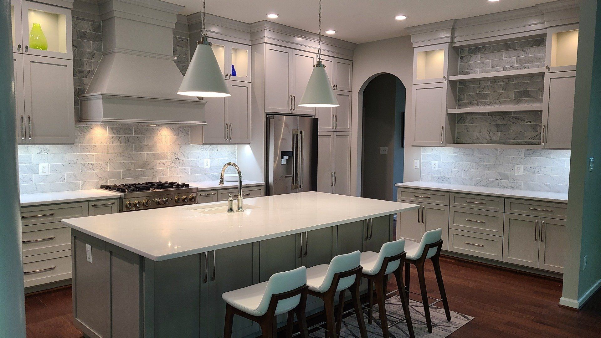 A kitchen with white cabinets and a large island