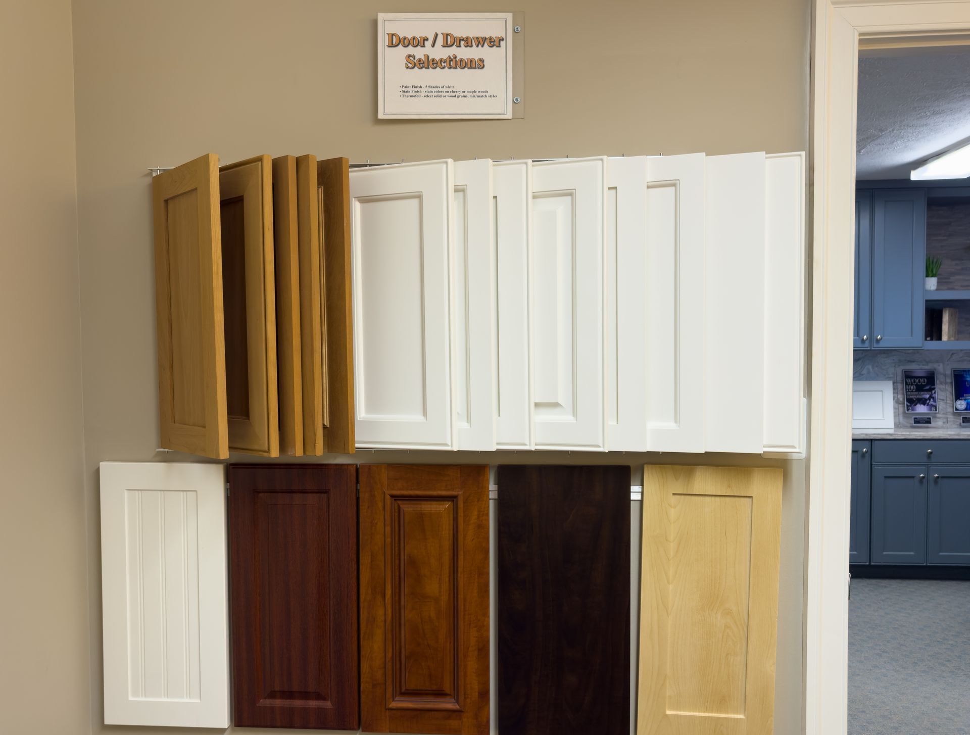 A display of different types of cabinet doors with a sign above them that says buyer / designer solutions