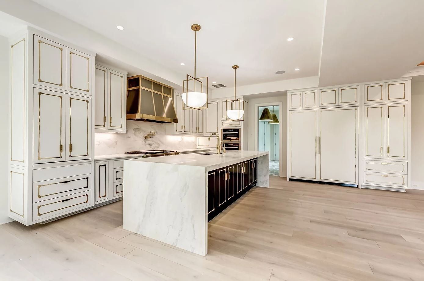 A kitchen with white cabinets and a large island