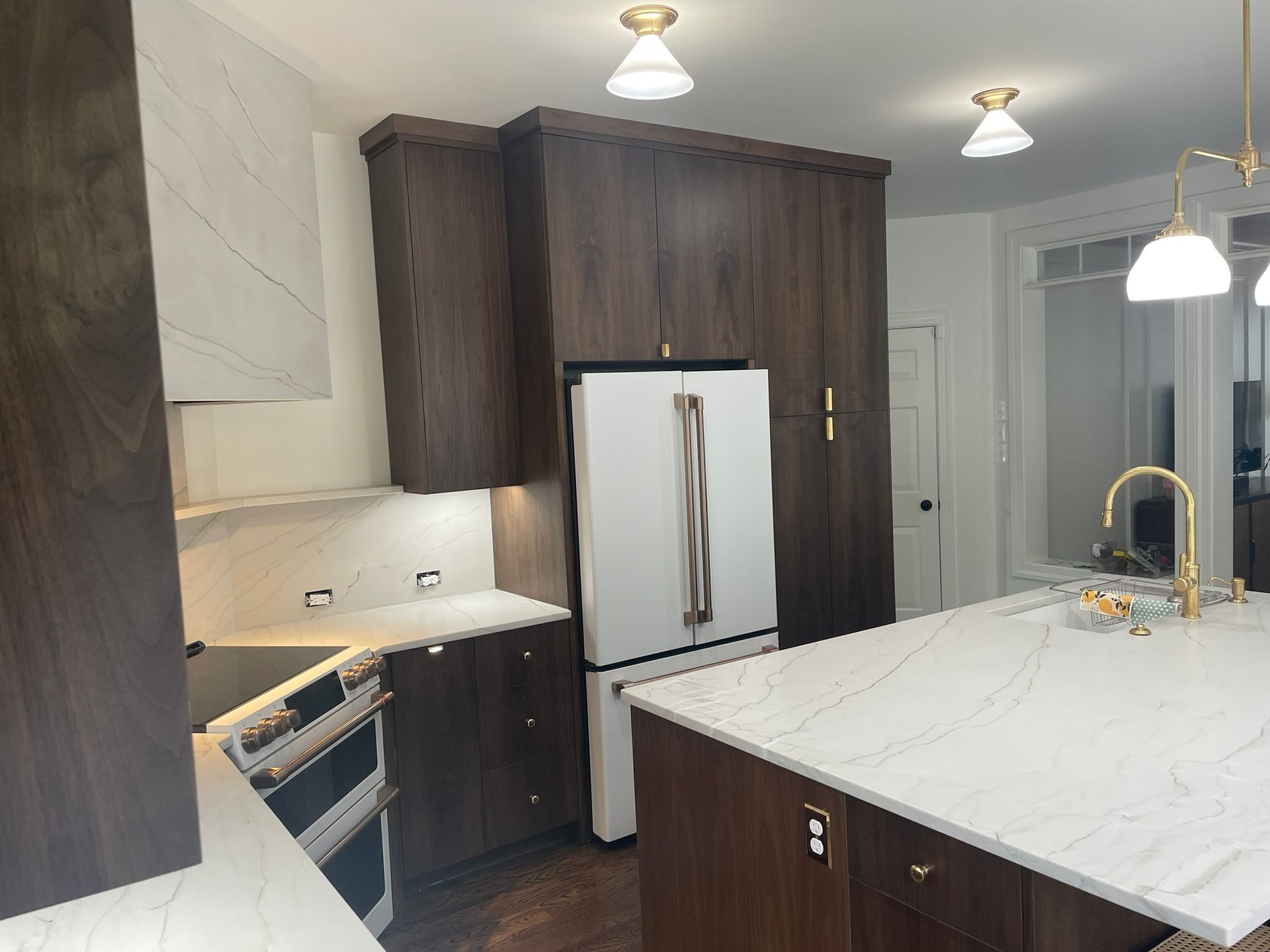 A kitchen with white cabinets and glass doors
