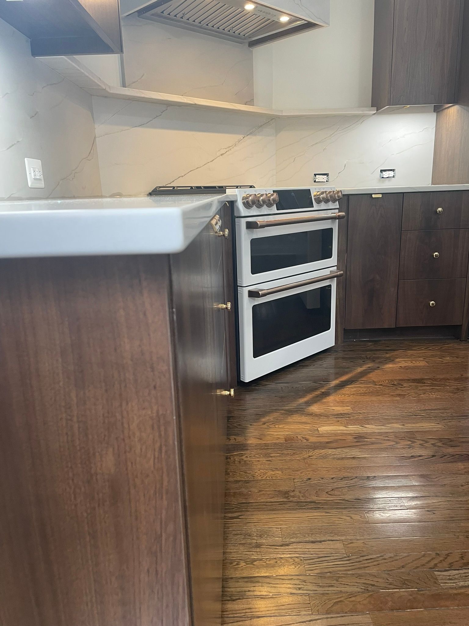 A stainless steel oven sits under a white cabinet