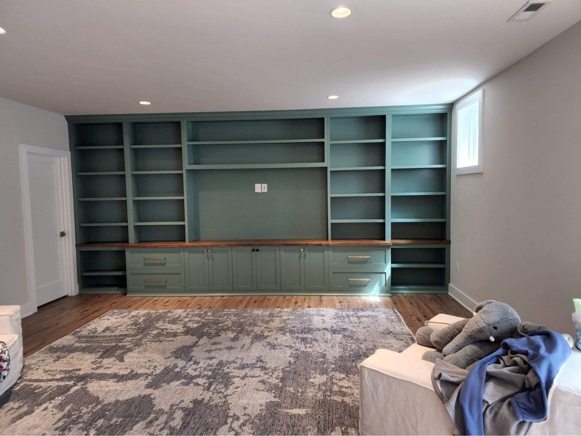 A living room with lots of shelves and a rug