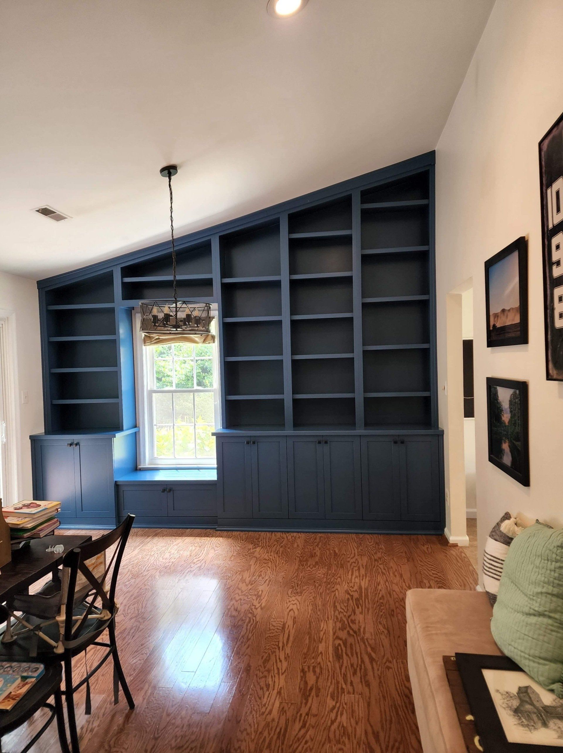 A living room with blue shelves and a window seat
